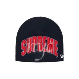 Gorro de lana tipo beanie color azul marino, con logo de Supreme bordado en rojo y decorado con aplicaciones de strass. Incluye logo de New Era en el lateral.