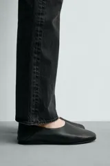 Mocasín de piel color negro con construcción desestructurada que permite usarlo como zapato destalonado. Cuenta con horma redonda, forro y plantilla de piel, y suela de goma VIBRAM®.