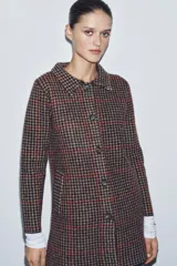 Abrigo de corte recto confeccionado en 100% lana, con estampado de pata de gallo en tonos tierra, negro y detalles en rojo. Presenta cuello solapa, cierre frontal con botones y bolsillos delanteros de vivo.