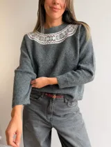 Sweater de punto gris con cuello redondo y diseño de guarda nórdica en tonos claros y bordó alrededor del escote. Presenta mangas largas con puños acanalados y un corte holgado.