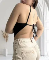 Top negro con tirantes finos que se cruzan en la espalda y terminan en un lazo.