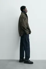 Parka de algodón con acabado lavado, color verde oscuro, de corte relajado. Presenta cuello subido, cierre frontal oculto por solapa con botones a presión, bolsillos de vivo en el pecho y bolsillos plastrón en la cadera.