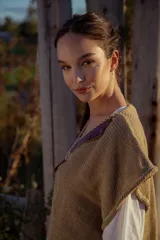 Chaleco tejido color tostado con apliques de cuero marrón en el cuello y detalle de pespunte en el contorno.