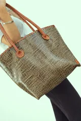 Bolso shopper de cuero azul con textura crocco, manijas largas marrones y costuras artesanales visibles en los bordes.