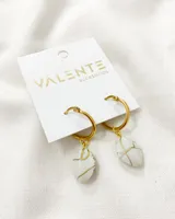 Aros tipo argolla de acero dorado con dije colgante de piedra blanca con vetas doradas estilo mármol.