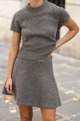 Jersey de punto color gris, con cuello redondo, manga corta y acabados en rib.