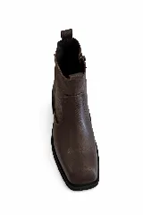 Bota corta de cuero color marrón con punta cuadrada y suela plana de goma negra.