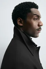 Sobrecamisa color beige de corte cuadrado, con cuello solapa, manga larga con puños abotonados, bolsillos laterales y cierre frontal con botones.