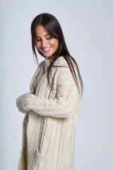 Cárdigan negro tejido con diseño de ochos, corte holgado y bolsillos frontales.