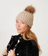 Gorro de punto acanalado en color blanco, con diseño de bajo plegado y pompón superior a tono.