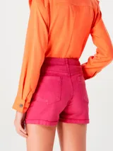 Short de jean verde con tiro alto, corte recto y ruedo desflecado.