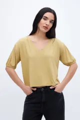 Remera color crudo con textura de tejido y escote en V, con mangas cortas abullonadas.