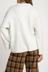 Sweater de punto en color gris melange, con diseño oversize, cuello polo y cierre frontal parcial. Presenta mangas largas y una textura acanalada suave.
