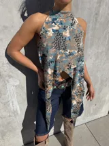 Top halter estampado con diseño animal print combinado en tonos celestes, marrones y negros, con cuello alto y paneles delanteros largos y cruzados.