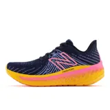 Championes de running New Balance WVNGOEM5 para dama, color azul marino con detalles en rosa y amarillo.