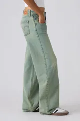 Pantalón de jean de tiro muy bajo con corte holgado y diseño de canesú en la cintura. Presenta un lavado desgastado en tono azul claro con costuras visibles.