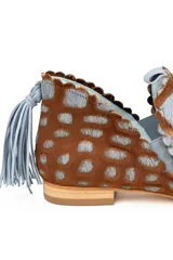 Botín artesanal de piel de potro con estampado animal print tipo jirafa en tonos marrón y azul. Presenta diseño de dos piezas con bordes troquelados, aberturas laterales y detalle de borlón trasero en ante azul. Incluye cuña interna y suela de cuero.