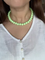 Gargantilla de cuentas esféricas de color verde claro.