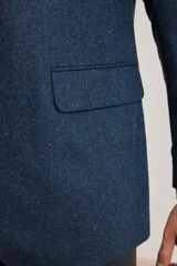 Blazer azul de corte slim, confeccionado en tejido con mezcla de lana. Tiene cuello con solapas, manga larga con puños abotonados, bolsillos de solapa en la cadera, abertura en la espalda y cierre frontal con botones.