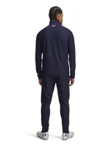 Conjunto deportivo Under Armour de hombre, compuesto por campera y pantalón en color azul marino. La campera presenta cierre frontal completo, cuello alto y detalles de líneas blancas en el pecho con el logo de la marca. El pantalón cuenta con cintura elástica y calce cómodo ideal para entrenamiento.