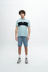 Remera polo azul marino con cuello clásico, tapeta de dos botones y mangas cortas. Presenta un diseño de líneas horizontales texturizadas en la parte superior del pecho y logo bordado en el lateral.