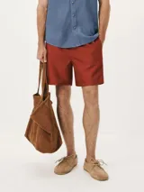 Short de baño color rojo, de corte recto y largo medio, con cintura elástica y bolsillos laterales.