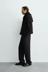 Cazadora de corte regular fit, color negro, confeccionada en tejido efecto ante. Presenta cuello solapa, manga larga con puños abotonados, bolsillos de plastrón con solapa en el pecho y bolsillos laterales en la costura de la cadera. Cierre frontal con botones a presión.