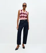 Chaleco de punto con escote en V y diseño de cuadros tipo argyle en tonos rosa y bordó. Presenta terminaciones acanaladas en cuello, sisas y ruedo.