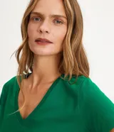 Remera básica celeste de media malla, con escote en V y mangas cortas.