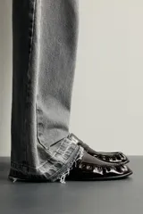 Mocasín de vestir negro con parte superior lisa y detalle de antifaz en el empeine, con suela a tono y ligero tacón.