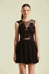 Top negro sin mangas de Natalia Antolín, confeccionado con base transparente y apliques de encaje floral bordado con cuentas en la parte frontal y en los hombros.