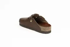 Zueco de gamuza color marrón con tira ajustable mediante hebilla metálica dorada, suela de corcho y base de goma estriada.
