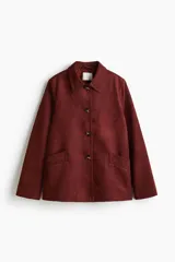 Chaqueta de tejido suave con acabado efecto gamuza, cuello camisero, cierre frontal con botones y bolsillos delanteros insertados.