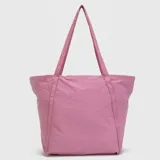 Bolso tipo tote de diseño amplio y ligero, confeccionado en tela técnica de acabado mate. Presenta doble asa superior para llevar al hombro, bolsillo frontal abierto y logo de la marca sutilmente grabado en la parte superior.