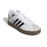 Championes Adidas modelo VL Court 3.0 para mujer, de color blanco con detalles en negro y suela de goma marrón. Presentan un diseño de corte bajo con las tres tiras clásicas de la marca en los laterales y puntera de gamuza en tono gris claro.