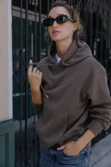 Sudadera de manga larga con capucha ajustable mediante cordones, bolsillo frontal tipo canguro y puños y ruedo en tejido rib.