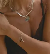 Pulsera de cadena de acero con dos dijes colgantes en forma de cruz.