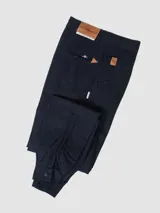 Pantalón de vestir negro, de corte recto, con bolsillos laterales y traseros. Se ajusta a la cintura con cinturón de cuero marrón.