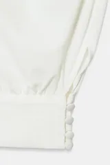 Top halter blanco de diseño fluido con frunces en el cuello, mangas murciélago y bajo con acabado tipo globo.