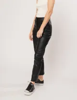 Pantalón negro estilo jeanero confeccionado en gabardina elastizada con terminación metalizada, pierna recta con largo por arriba del tobillo, cierre delantero y botón.