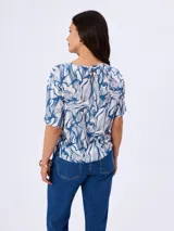 Blusa de viscosa con cuello redondo y mangas cortas, con diseño estampado en tonos azules y blancos.
