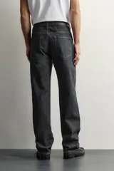 Jeans straight fit de denim oscuro de origen italiano, con tiro bajo, pierna recta y cinco bolsillos. Cierre frontal con botones.