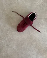 Championes de cuero vacuno con diseño de paneles en tonos marrones y detalles en blanco. Presentan una combinación de texturas lisas y grabadas, con cordones planos y costuras decorativas en la lengüeta.