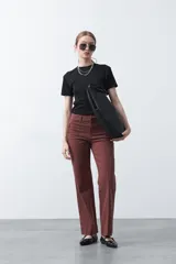 Pantalón de mujer color beige, de corte recto y tiro alto, con costuras frontales marcadas que recorren la pierna.