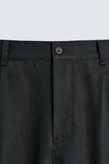 Pantalón de corte relajado confeccionado en una mezcla de lino y viscosa. Presenta bolsillos delanteros, bolsillos traseros de plastrón y cierre frontal con cremallera y botón.