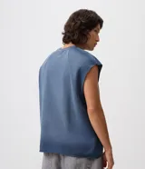 Musculosa boxy azul de algodón liviano, con cuello redondo, recortes raglán, sisas sin dobladillo y estampa frontal con lettering de Bad Manners.