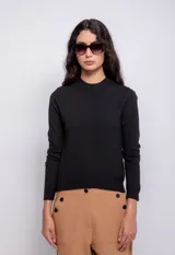 Polera gris de tejido de punto, cuello alto y mangas largas.