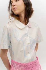 Vestido midi camisero negro con estampado floral, cuello camisero, manga corta y cierre frontal con botones.