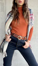 Polera de punto acanalado color terracota, de cuello alto y manga larga.