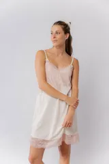 Camisón de algodón con escote en V y ruedo decorados con puntilla elastizada. Presenta breteles finos ajustables con pequeños lazos decorativos.